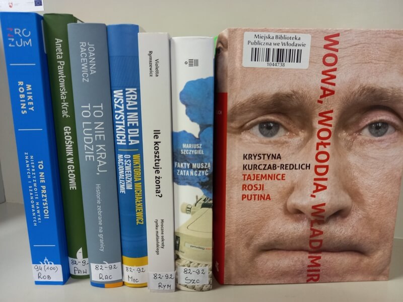 Sześć książek stojących, widoczne grzbiety, jedna książka stojąca widoczna okładka: Krystyna Kurczab-Redlich: Wowa, Wołodia, Władimir. Tajemnice Rosji Putina.