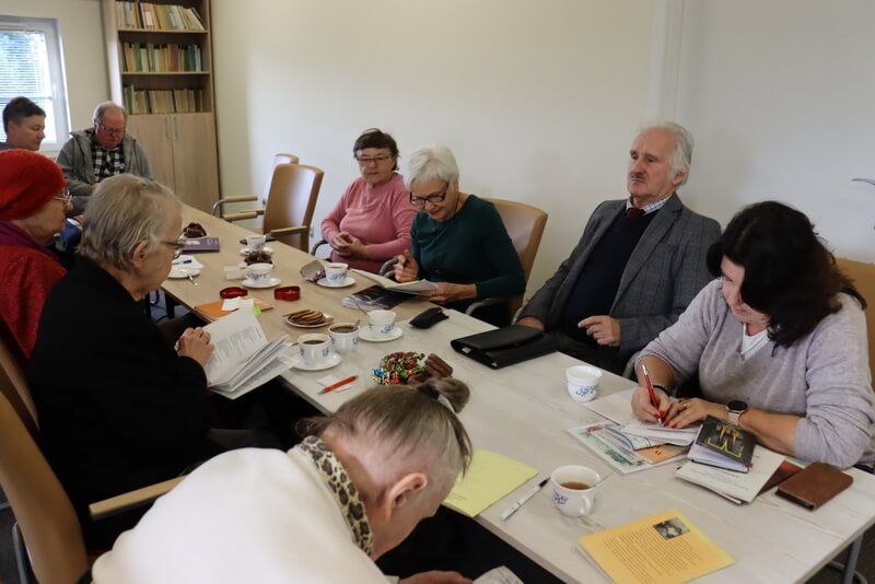 Grupa ludzi siedzących przy stole